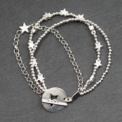 Silver star charm bracelet with multiple strands and T-bar clasp by Suzie Blue Canada, featuring a shiny metallic finish.