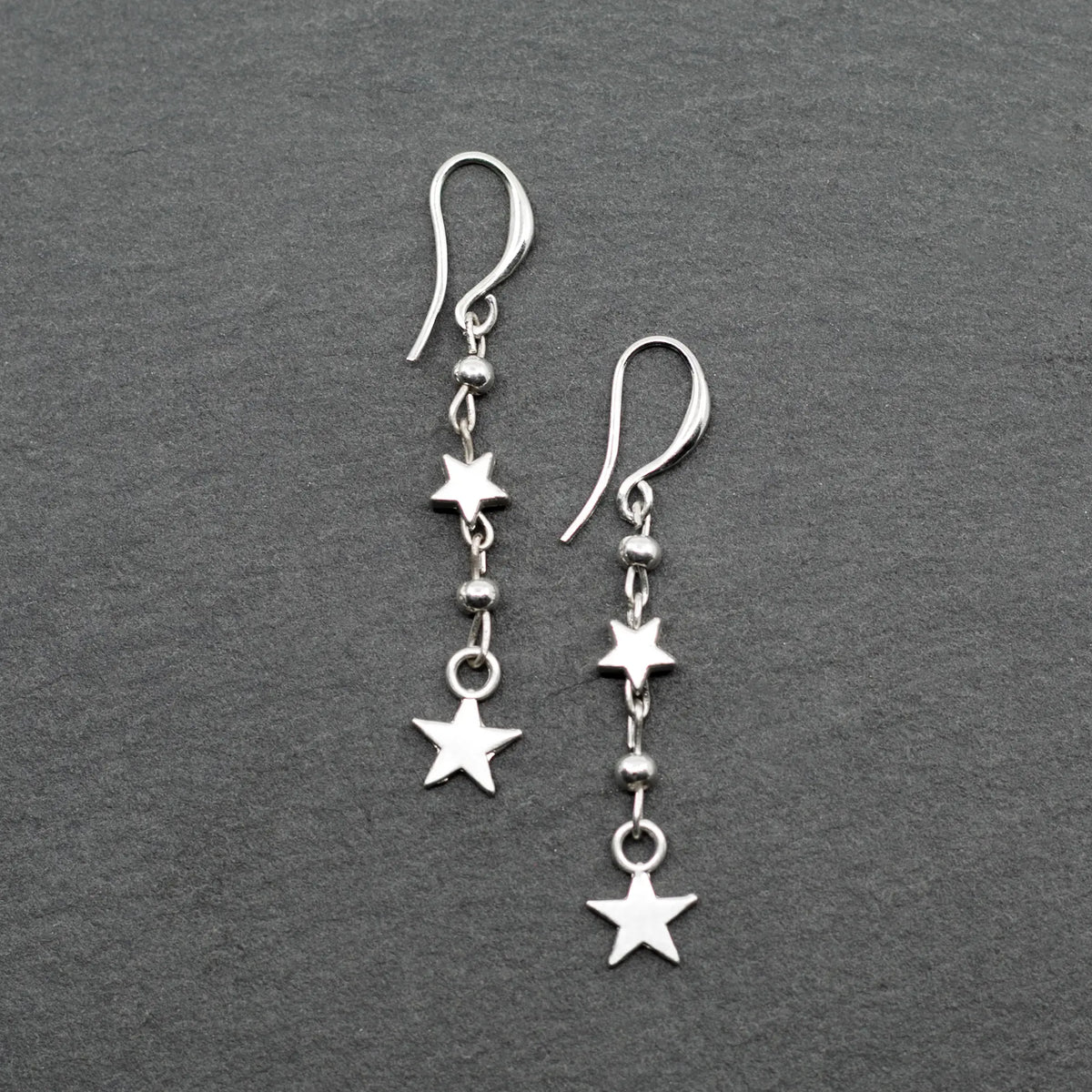 Silver star drop earrings with double drop design by Suzie Blue Canada, featuring charming silver plating and elegant style.