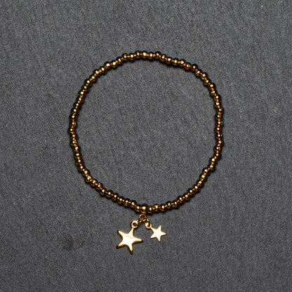 Gold star charm bracelet with elasticated design in gold plate, featuring star-shaped charms, by Suzie Blue Canada.