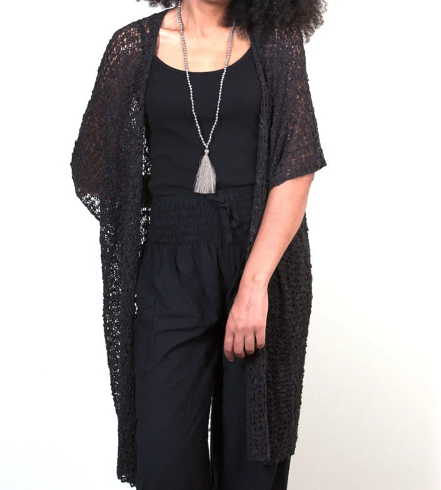 Mid-length black kimono in popcorn knit style by Suzie Blue Canada, shown on a hanger with open front and long sleeves.