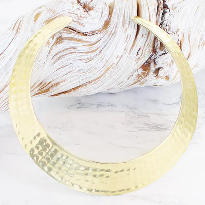 Gold-colored beaten metal collar necklace by Suzie Blue Canada, featuring a textured, bold design with a choker-style fit.