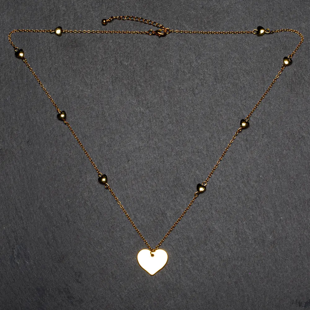 Gold plated heart necklace with layered heart chain design by Suzie Blue Canada, featuring a stylish and elegant jewelry piece.