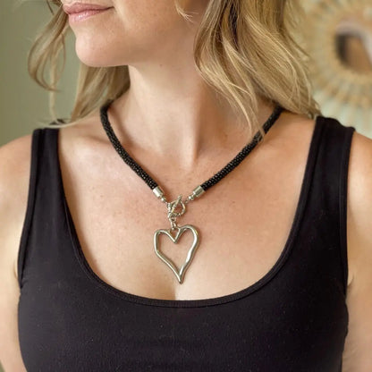 Short beaded heart necklace with open heart pendant from Suzie Blue Canada, featuring delicate beaded design and silver-tone accents.