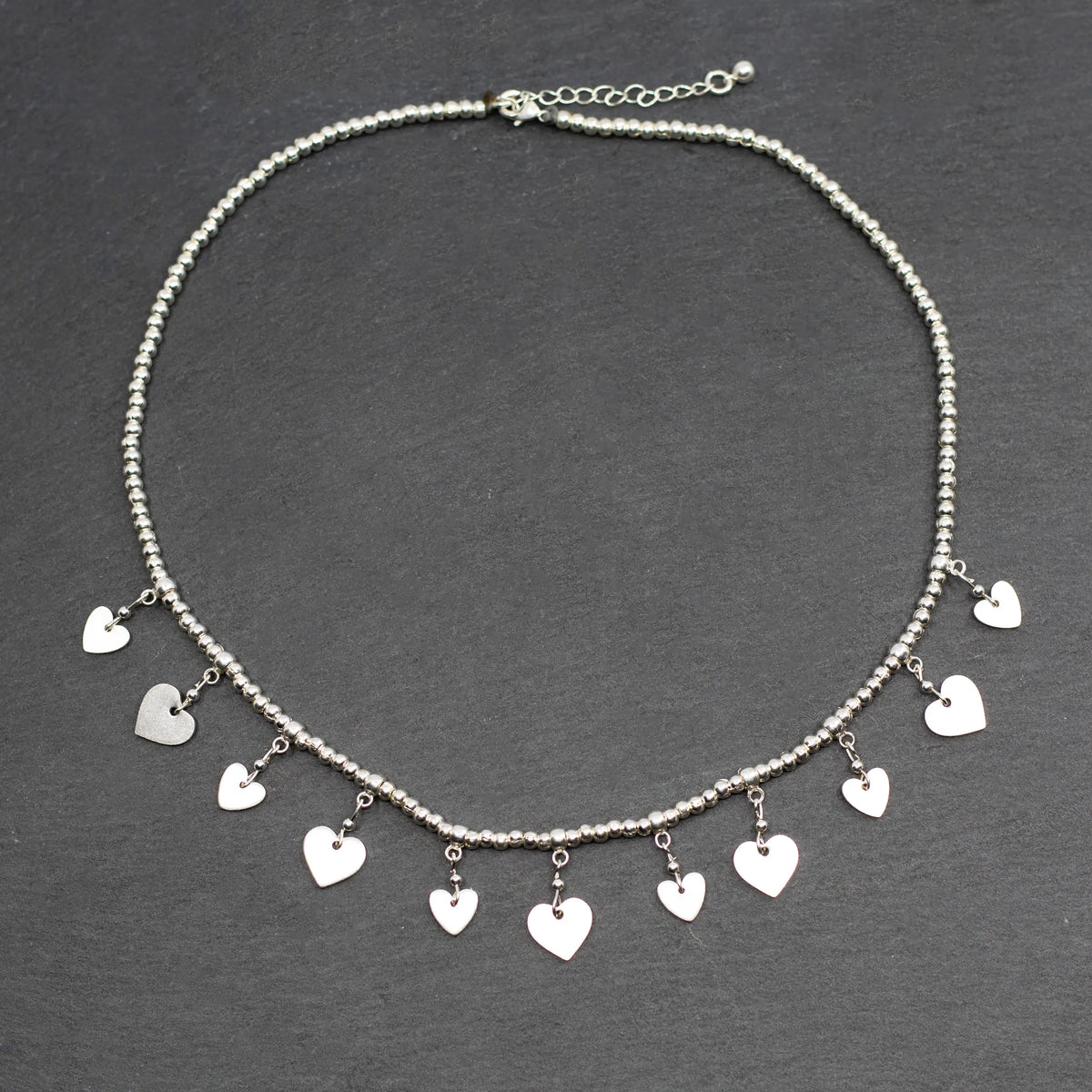 Silver plate charm necklace with drop heart pendants, elegant short design by Suzie Blue Canada.