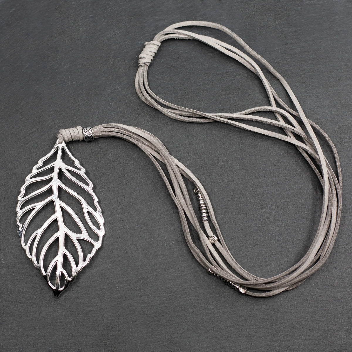 Silver-plated suede necklace featuring a leaf pendant, designed by Suzie Blue Canada, showing the pendant against a neutral background.