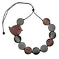 Fat bird necklace on wooden disc, nature-inspired jewelry by Suzie Blue Canada featuring a charming bird design and rustic wood background.