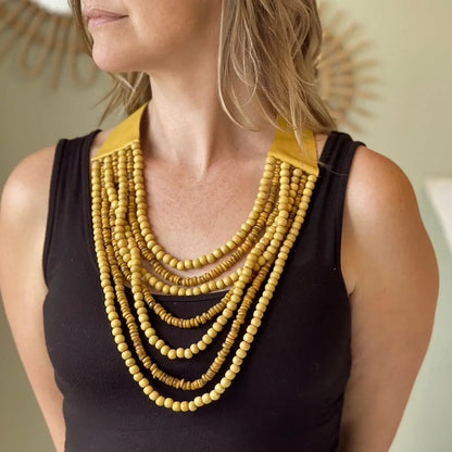 Multi strand wooden bead necklace by Suzie Blue Canada featuring various natural wooden beads and a stylish layered design.