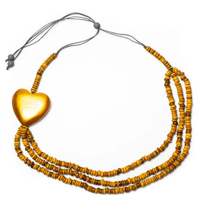 Triple strand coconut bead necklace with wooden heart accent by Suzie Blue Canada, featuring natural beads and a wooden heart pendant.