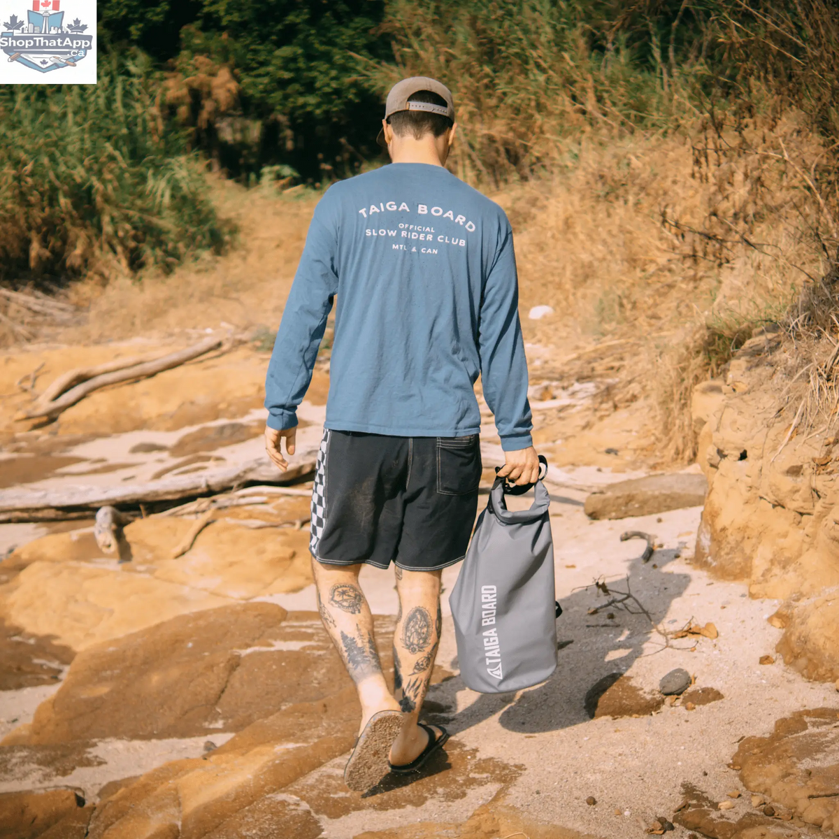 Taiga Board 20L dry bag with adjustable carbon paddle, waterproof gear storage for water sports activities.