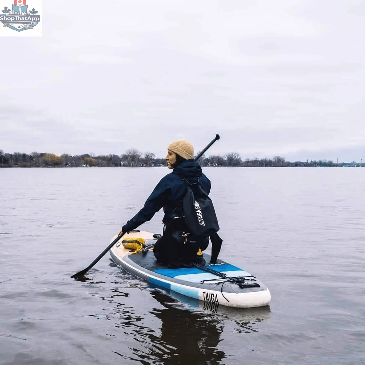 Taiga Board 20L dry bag with adjustable carbon paddle, waterproof gear storage for water sports and outdoor adventures.