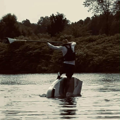 Taiga Board Freestyle 9'10" inflatable SUP paddle board on water, showcasing its sleek design and sturdy construction.