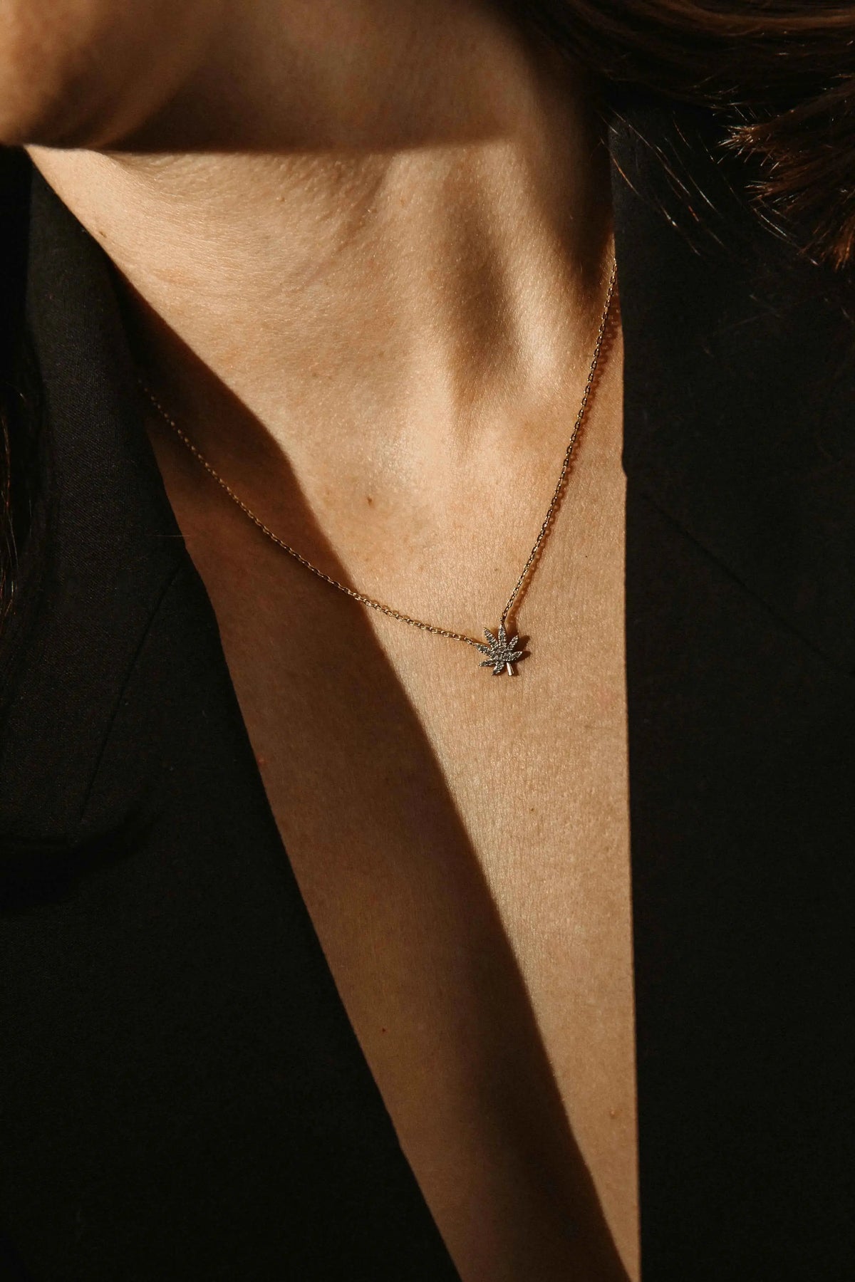 Silver cannabis leaf necklace from The Kush Girls featuring a detailed pendant on a chain.
