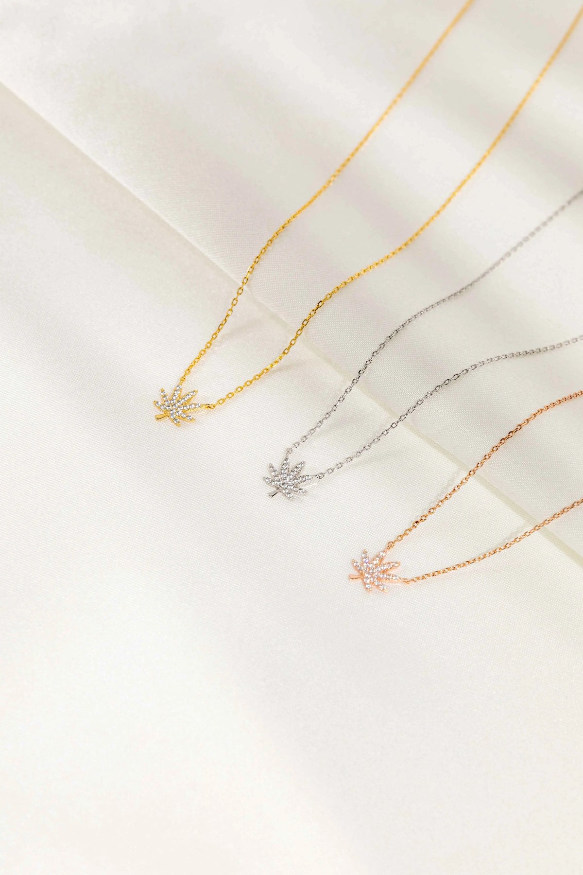Silver cannabis leaf pendant necklace by The Kush Girls, featuring a detailed cannabis leaf charm on a sleek chain.