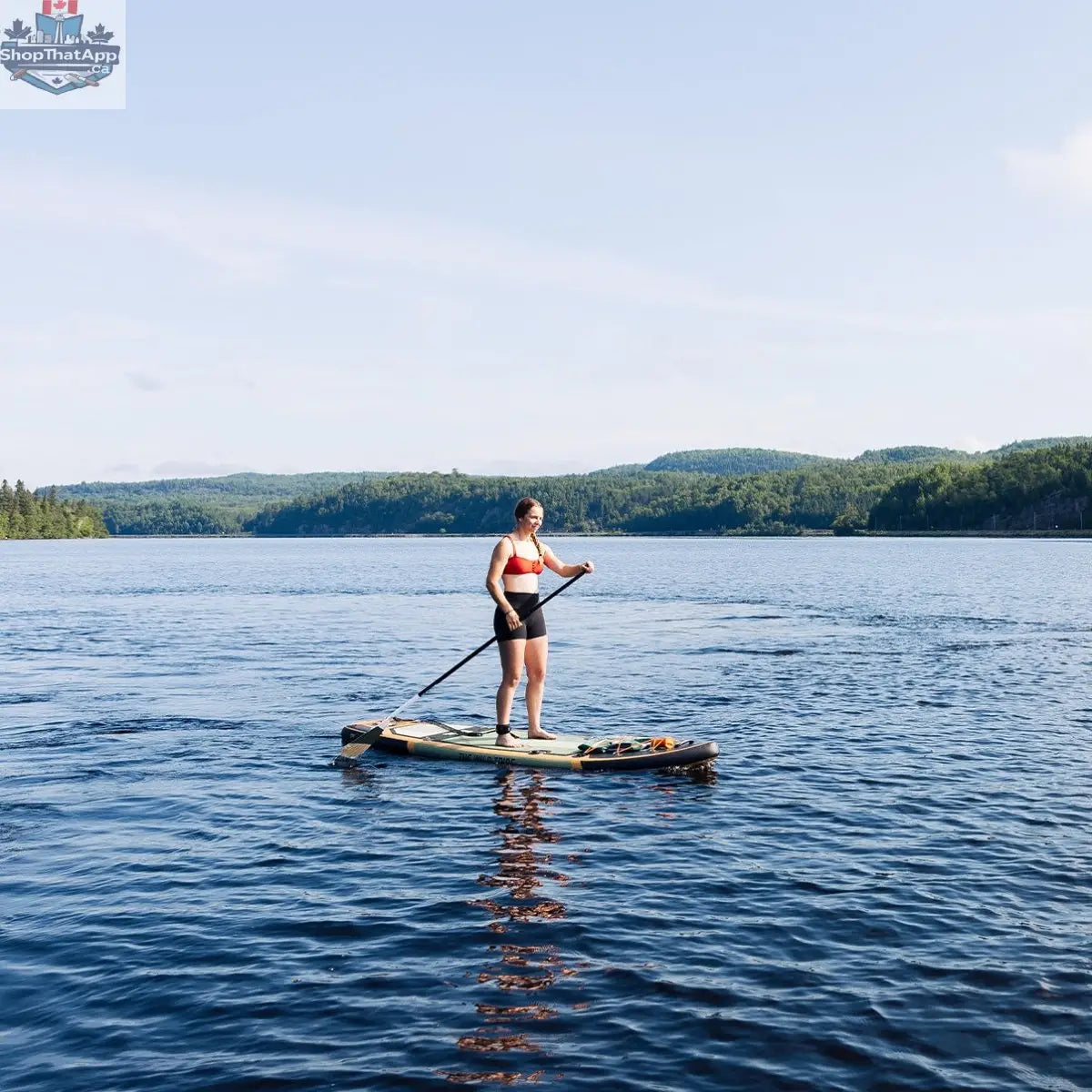 Green Sequoia XL inflatable paddleboard by The Wild Tribe, 11-foot lightweight and durable stand-up paddleboard on water.