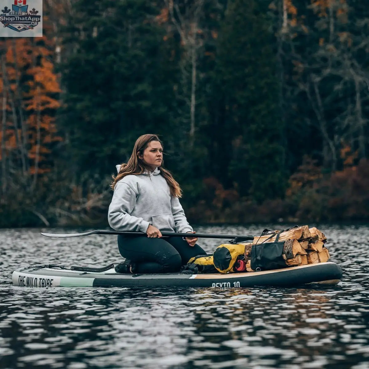 Inflatable Peyto 11' paddleboard by The Wild Tribe, shown on water with paddle, designed for stability and outdoor paddling adventures.