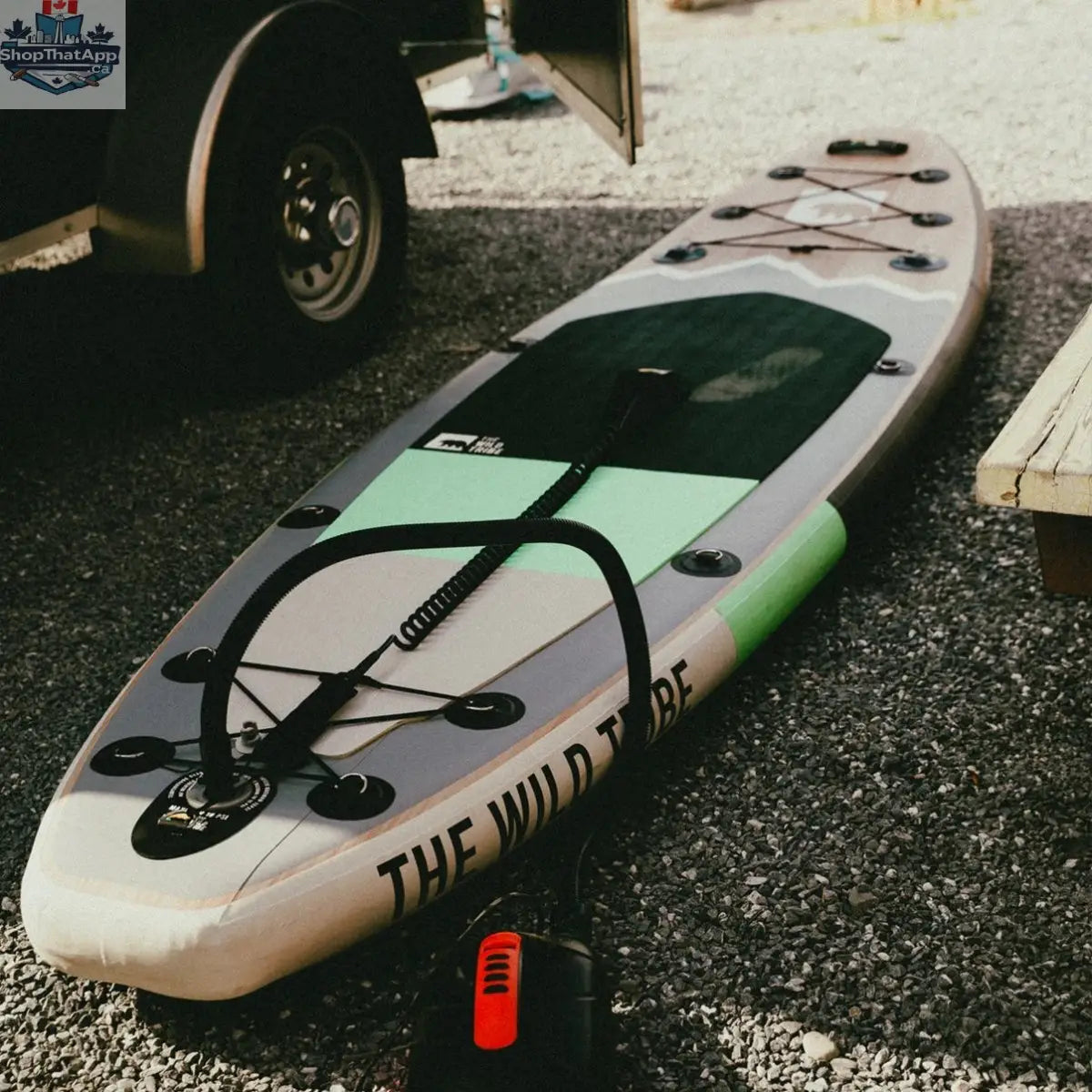 Inflatable Peyto 11' paddleboard by The Wild Tribe, shown on water with adjustable paddle and pump for recreation and fitness.