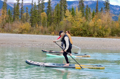Golden Peyto 11' inflatable paddleboard by The Wild Tribe, designed for all-around use, shown on water with paddle and gear.