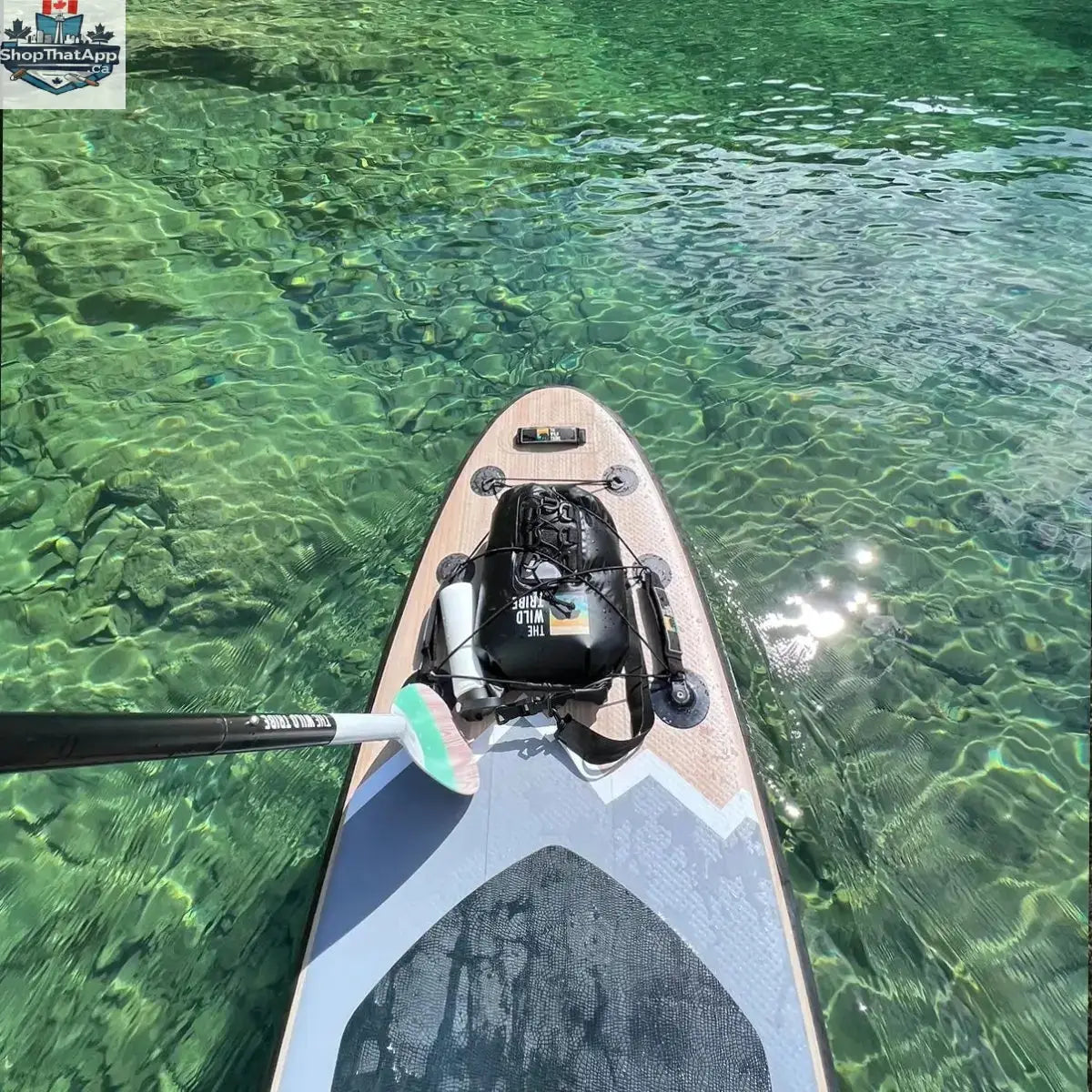 Inflatable Peyto 11' paddleboard by The Wild Tribe, shown on water with paddle and gear for outdoor paddling adventures.
